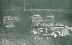A late-1950s action shot of George Giesen’s No. 7 Ford coupe leading the pack out of turn four at Outagamie Speedway. On the billboard directly behind the cars is an ad for Carl W. Krause Excavating. Krause was the owner of Outagamie Speedway. (Submitted photo)