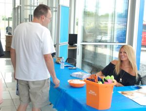 Courtney Hansen autographs a photo for a guest at Klein Automotive Wednesday, July 6. Jeff Hoffman photo